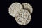 Three round rice crackers on a black background close-up