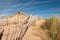 Three rows of broken fence on sand dunes