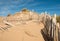 Three rows of broken fence on sand dunes horizontal wide