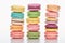 Three rows of sweet multicolored French macaroons of different flavors on white background.