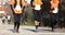 Three runners run on asphalt road outdoors