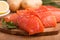 Three salmon pieces on a chopping board