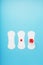 Three Sanitary pads on a blue background. The concept of critical days, menstrual cycles in several stages