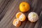 Three satsuma oranges on a rustic wood table