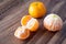 Three satsuma oranges on a rustic wood table