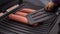 Three sausages toasted on electric grill, dog paw with plastic kitchen spatula