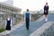 Three schoolchildren of different ages, stand with backpacks behind their back, in school uniforms