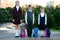 Three schoolchildren with portfolios stand on the growth in the street