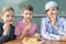 Three schoolchildren sitting at a table in a cafe eating shrimp in batter with french fries