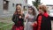 Three schoolchildren are walking along the street in halloween costumes. The faces of the children are painted, the