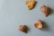 Three sea shells and a heart-shaped stone on a light blue background