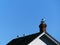 Three Seagulls on Top of a Roof and Red Brick Chimney of a gray Sided Building Against a Bright Blue Sky