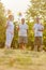 Three seniors hold wind turbines in summer