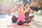 Three seniors at the spa hotel by the pool doing yoga exercise