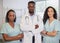 Three serious medical healthcare professionals stand in a row arms folded