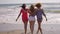 Three shapely female friends walking on a beach