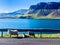 three sheeps along a street in front of a river in an idyllic landscape at wonderful weather in iceland