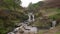Three Shire Heads. An autumnal waterfall and stone packhorse bridge at Three Shires Head in the Peak District