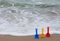 Three shovels in the beach sand with the ocean waves in the background