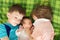 Three sibling children lying on bed in large family, hug and embrace