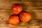 Three sicilian oranges on a wooden table. Top view