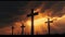 Three silhouetted religious crosses on hillside with orange sunset background, crucifixion concept.