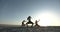 Three silhouettes of girls dancing synchronously on the beach