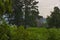 Three silo towers stand in a lush landscape in under cloudy skies