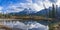 The Three Sisters trio peaks mountain reflect on water surface in autumn. Beautiful scenery at Canmore, Canadian Rockies