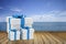 Three size of white square gift box with blue ribbon put on wooden table against sea view.copy space for add your text.gift