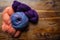 Three skeins of richly colored yarns gathered on an old wooden background, old world handcraft knitting and crochet, copy space