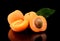 Three sliced apricots isolated on black