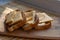 Three slices of hard cheese and butter sandwiches on oval bran bread, food on a wooden plank, breakfast and a snack