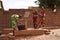 Three Small African Girls Happpily Managing A Borehole Hand Pump To Collect Water