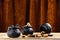 Three small cauldrons with different candies stand on a wooden table, with a velvet curtain in the background.