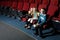 Three small children in 3D glasses watching a movie