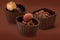 Three small chocolate baskets with cream and nuts