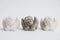 Three small identic handmade stone gyps angels on white background.