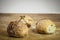 Three small loafs of French bread on display on a rustic wooden table, baguette style.