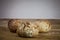 Three small loafs of French bread on display on a rustic wooden table, baguette style.