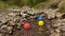 Three small primary colored plastic balls floating down the stream