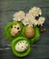 Three small quail eggs in side tiny green nests with relaxing fl