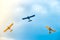 Three small two-pilot airplanes boldly making turns in the blue cloudy sky
