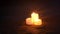 Three small yellow candles on sandy beach near sea ocean waves