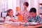 Three smart children making their classwork together.