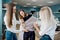 Three smart-looking pretty women wearing white shirts are looking at the tailor`s dummy and measuring it. Fashion