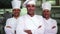 Three smiling chefs looking at camera making ok sign