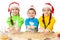 Three smiling kids showing Christmas cooking