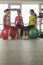 Three smiling mature women exercising with fitness balls in the gym