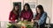 Three smiling positive relatives women cooking together in kitchen